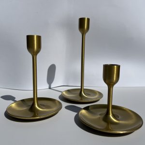 Elegant sæt af gyldne lysestager til festdekorationer og bordpynt.